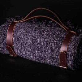 a purple Handmade Leather Bedroll Strap with a brown leather handle.