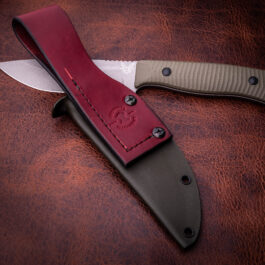 The Kydex Sheath for the Benchmade Anonimus is laying on a leather surface.