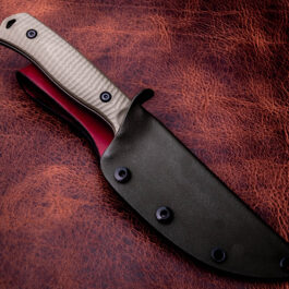 a Kydex sheath for the Benchmade Anonimus on a leather surface with a red handle.