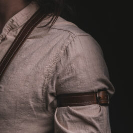 A close up of a person wearing Leather Dress Suspenders.