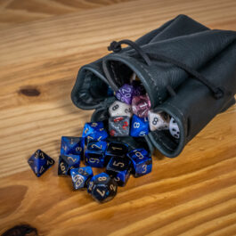 dices in a black leather dice pouch on top of a table - renaissance clothing - renaissance clothing men - renaissance clothing women - renaissance clothing near me - renaissance art clothing - renaissance era clothing - renaissance costume ideas