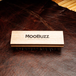 A tampico Fiber brush with a wooden handle that says "moobuzz" across its length