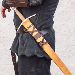 a man in a leather outfit holding a Wood Core Scabbard for the Albion I:33.