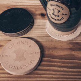 a stack of round leather coasters next to a mug