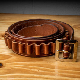 a light brown leather belt with bullet loops on a wooden table
