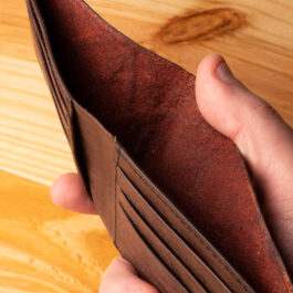 A leather wallet sitting on a wooden table