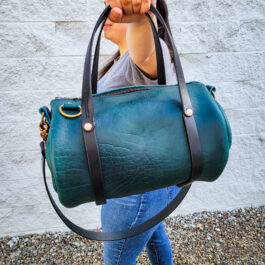 A woman carrying a Bison Leather Mini Duffel.