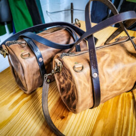 A Horween Derby Mini Duffel sitting on top of a wooden table.