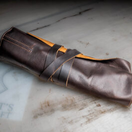 A Handmade Leather Kitchen Knife Roll sitting on top of a table.