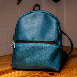 a cobalt blue mini backpack with black straps and hardware