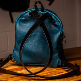 a cobalt blue mini backpack with black straps and hardware